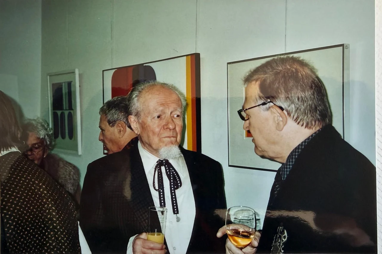 Hilko Weerda und H. Kreutz im Gespräch vor ausgestellten Bildern.