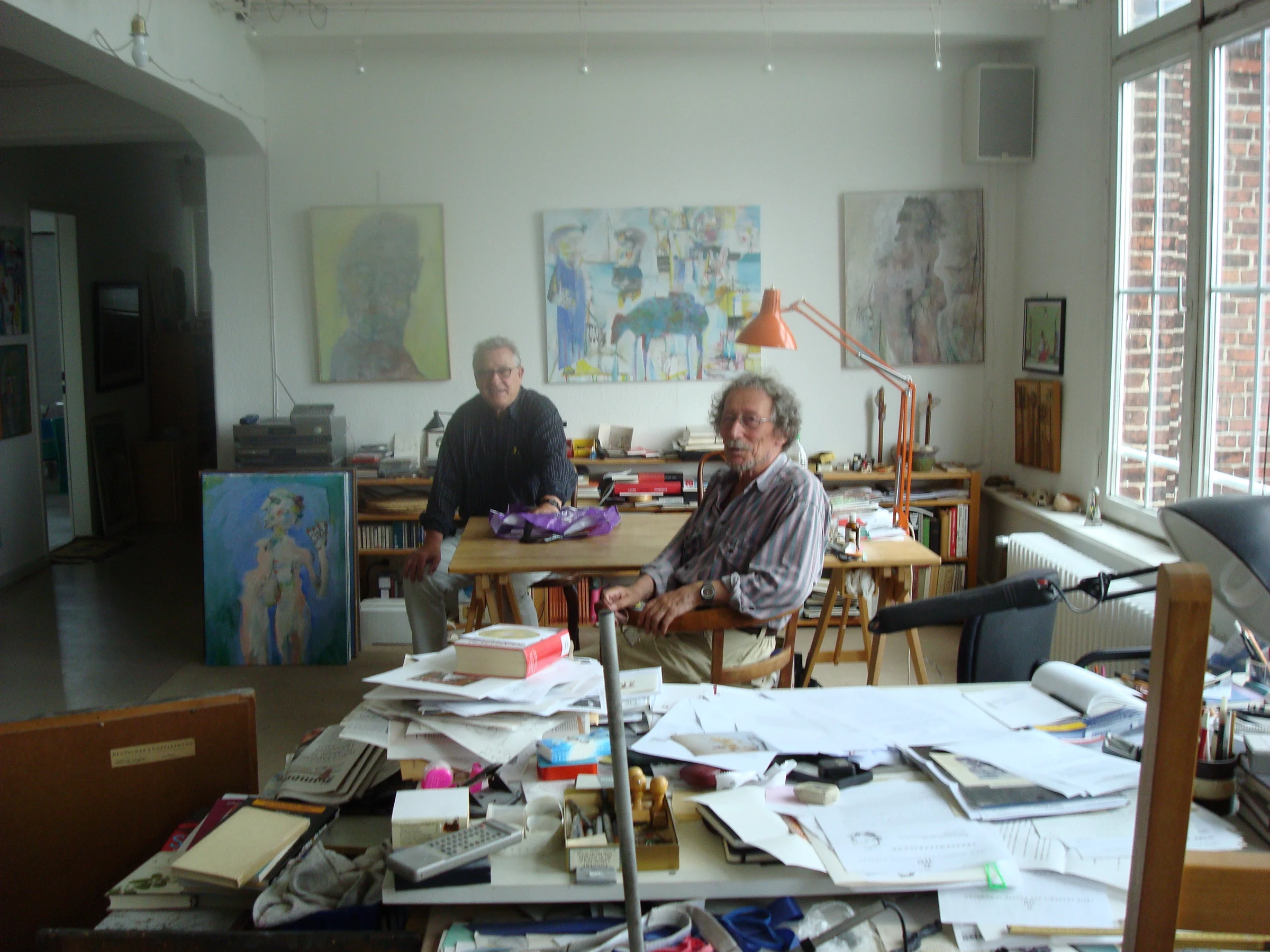 Hilko Weerda und Armin Sandig im Atelier, zwischen Bildern, Büchern und Arbeitstischen.